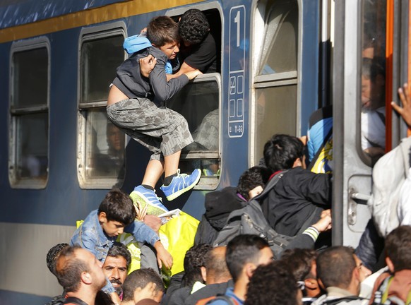Migrants storm into a train at the Keleti train station in Budapest, Hungary, September 3, 2015 as Hungarian police withdrew from the gates after two days of blocking their entry. REUTERS/Laszlo Balog ...