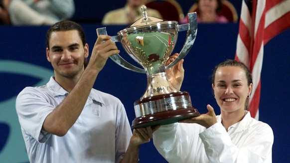 Roger Federer, left, and Martina Hingis of Switzerland hold the Hopman Cup aloft after they won both the singles matches against the United States at the final of the Hopman Cup in Perth, Australia, S ...