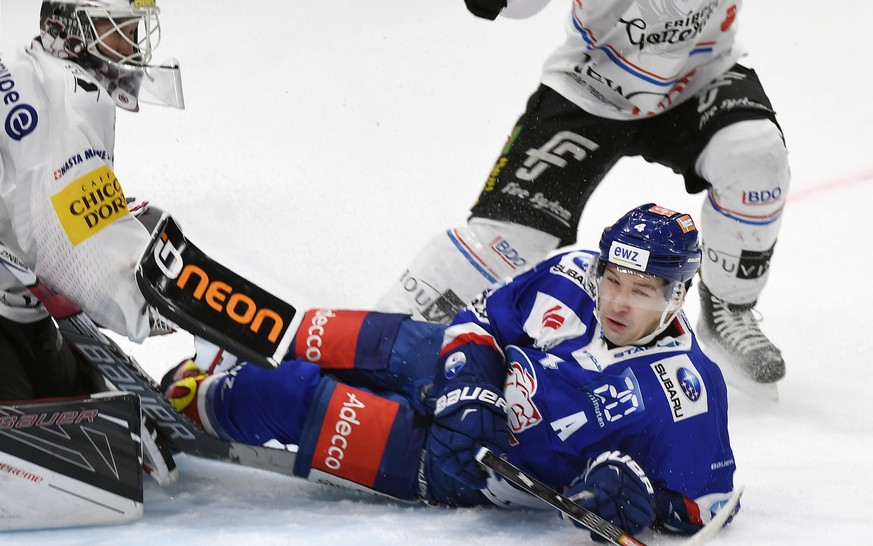 Zuerichs Patrick Geering, rechts, am Boden gegen Fribourgs Torhueter Dennis Saikkonen, links, beim Eishockeyspiel der National League A zwischen den ZSC Lions und dem HC Fribourg-Gotteron, am Sonntag, ...