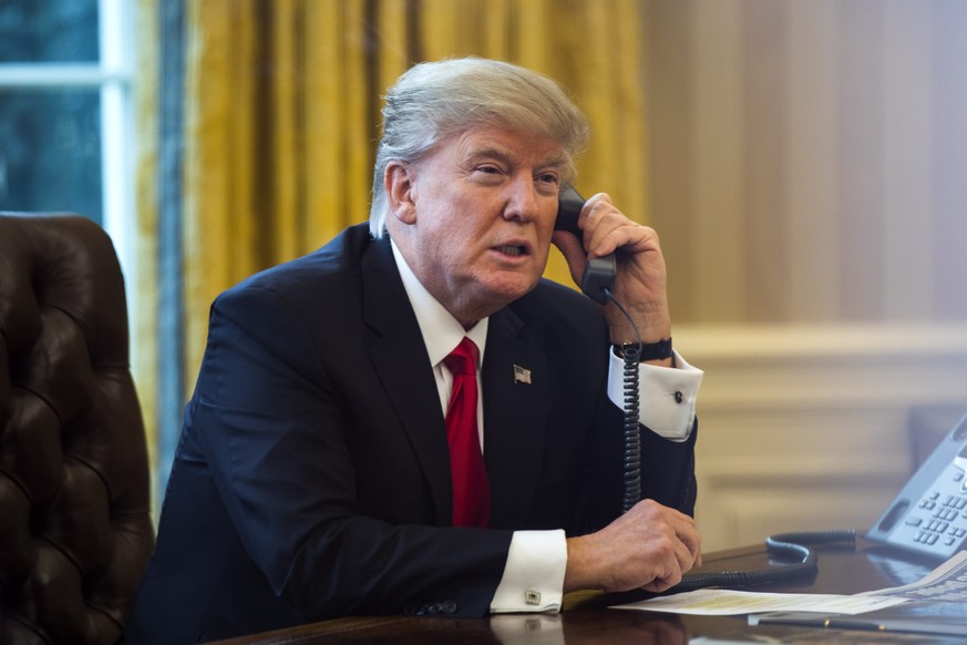 epaselect epa05760196 US President Donald J. Trump speaks on the phone with the King of Saudi Arabia, Salman bin Abd al-Aziz Al Saud, in the Oval Office in Washington, DC, USA, 29 January 2017. EPA/JI ...