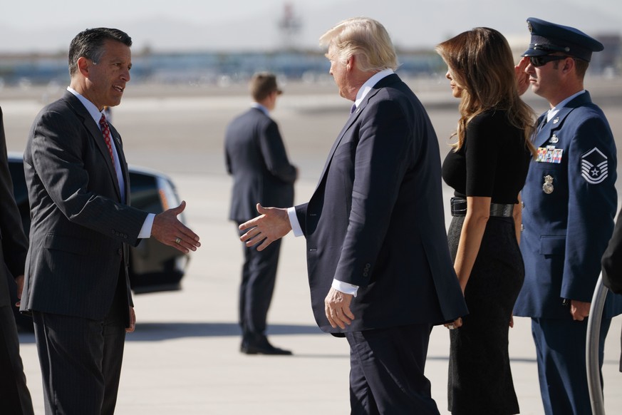 Nevada Gov. Brian Sandoval, left, greets President Donald Trump and first lady Melania Trump as they arrive Wednesday, Oct. 4, 2017, at Las Vegas McCarran International Airport to meet with victims an ...