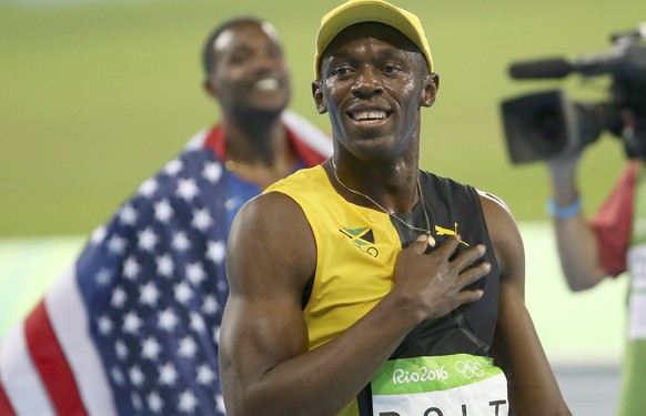 2016 Rio Olympics - Athletics - Final - Men&#039;s 100m Final - Olympic Stadium - Rio de Janeiro, Brazil - 14/08/2016. Usain Bolt (JAM) (R) of Jamaica celebrates after his gold medal win in the men&#0 ...