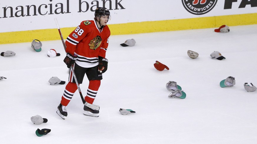 Chicago Blackhawks&#039; Patrick Kane skates between several hats after scoring a hat trick against the Pittsburgh Penguins, during the third period of an NHL hockey game Wednesday, March 1, 2017, in  ...