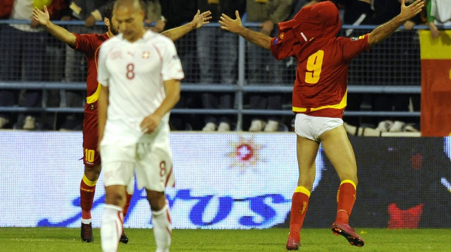 Montenegro forward Mirko Vucinic, right, celebrates the first goal in front of Swiss midfielder Goekhan Inler, left, during the Euro 2012 group G qualification soccer match between Switzerland and Mon ...