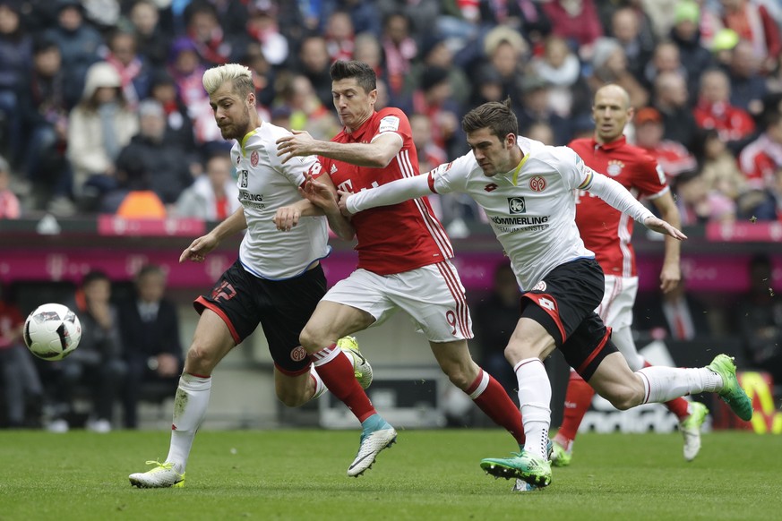 Bayern&#039;s Robert Lewandowski, center, Mainz&#039;s Alexander Hack, left, and Mainz&#039;s Stefan Bell challenge for the ball during the German Bundesliga soccer match between FC Bayern Munich and  ...