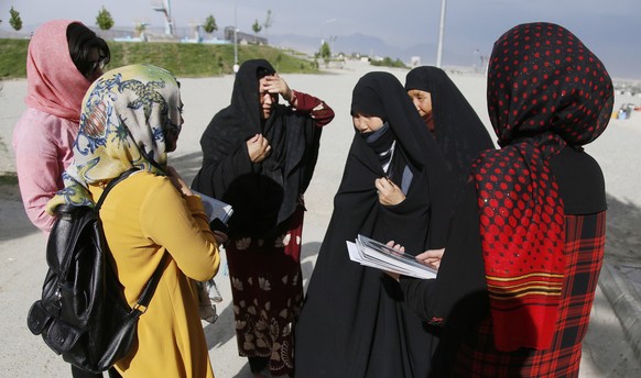 epa05988914 Female members of Afghanistan&#039;s first women magazine talk with burqa clad women as they introduce them to Gellara magazine in Kabul, Afghanistan, 23 May 2017 (issued 25 May 2017). Fat ...