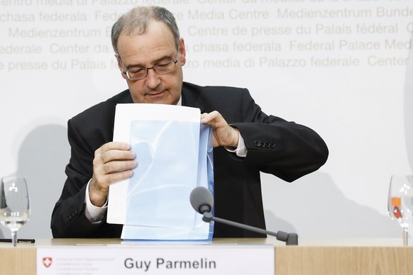Bundesrat Guy Parmelin packt seine Unterlagen in eine Mappe, an einer Medienkonferenz ueber das Nachrichtendienstgesetz, am Montag, 13. Juni 2016 in Bern. (KEYSTONE/Peter Klaunzer)