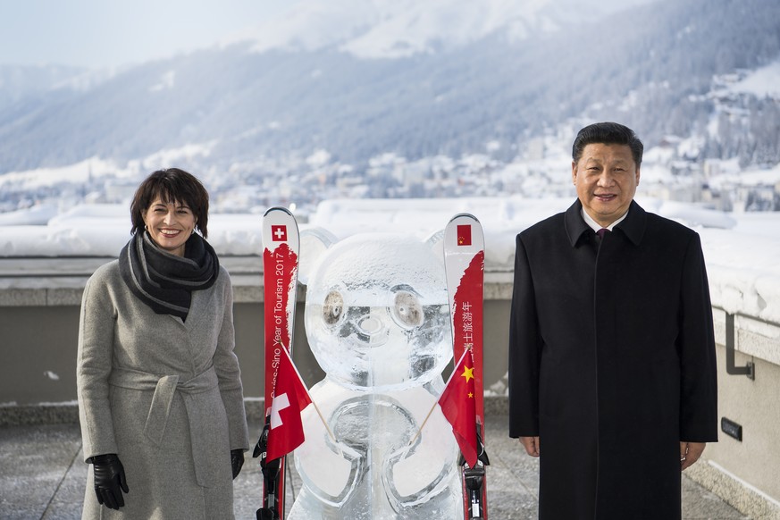 Swiss Federal President Doris Leuthard, left, poses with China&#039;s President Xi Jinping, right, as they launch of the Swiss-Sino year of tourism next to a panda ice sculpture on the side line of th ...