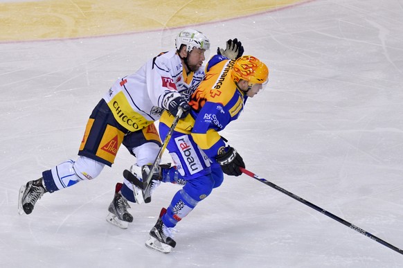 Der Zuger Emanuel Peter, links, versucht den Davoser PostFinance TopScorer Perttu Lindgren (FIN) aufzuhalten, waehrend dem Eishockey-Qualifikationsspiel der National League A zwischen dem HC Davos und ...