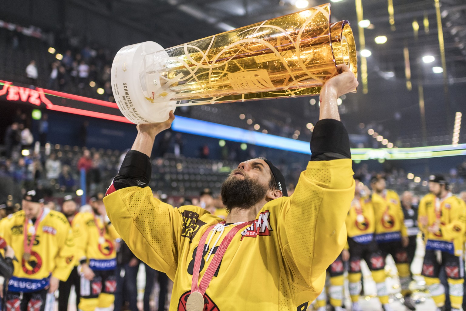 Der Berner Thomas Ruefenacht stemmt den Meisterpokal und feiert mit seiner Mannschaft als Eishockey Schweizermeister nach dem sechsten Eishockey Playoff-Finalspiel der National League A zwischen dem E ...