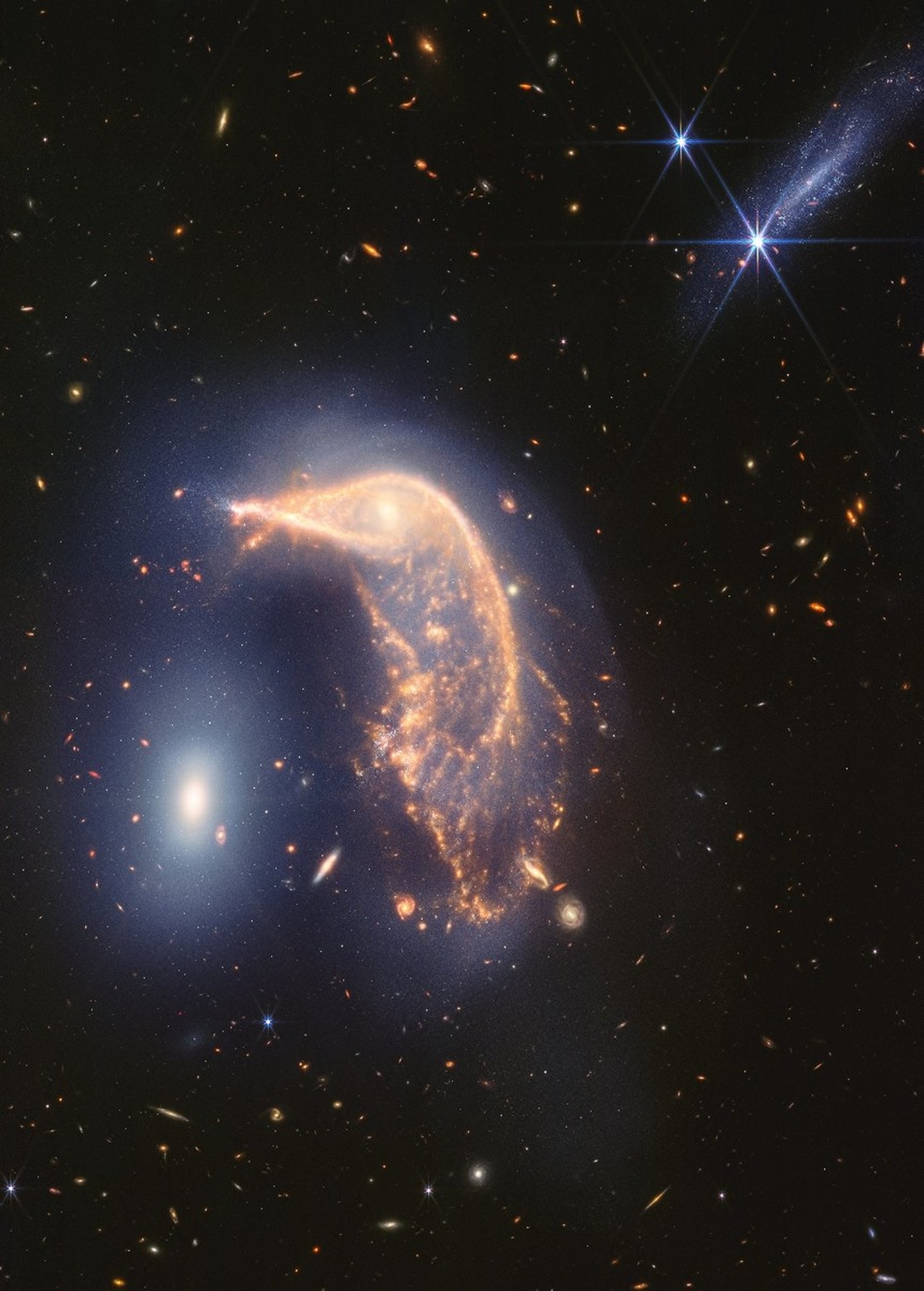 Nachrichten Linkding This new Webb image shows two galaxies: a Penguin (NGC 2936) guarding an Egg (NGC 2937). Webb's observations reveal the two are in a cosmic hug, joined together by a blue haze of stars and gas.
W ...