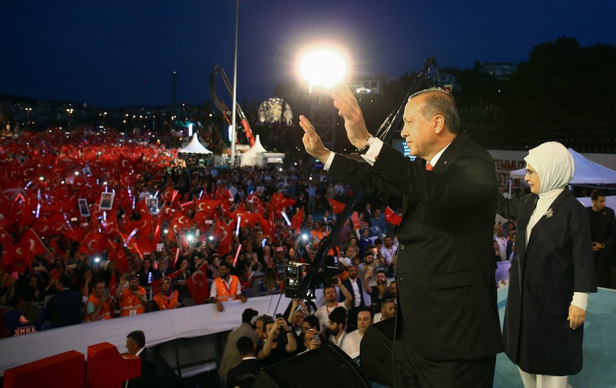 epa06090041 A handout photo made available by the Turkish Presidental Press Office shows Turkish President Recep Tayyip Erdogan (C) and his wife Emine Erdogan (R) greeting supports during a rally for  ...