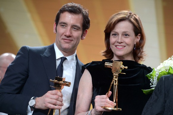 Clive Owen und Sigourney Weaver sind ganz aus dem Häuschen, nachdem sie eine Goldene Kamera gewonnen haben.