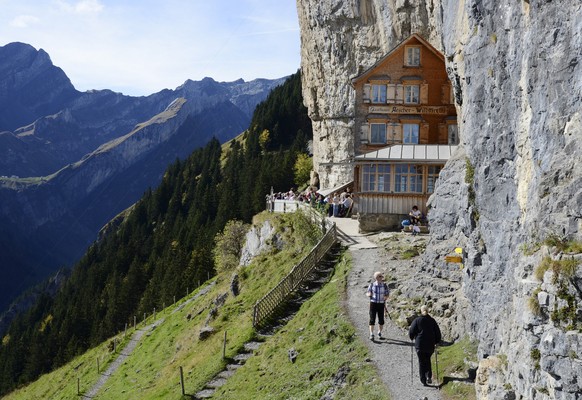 Ausfluegler goennen sich bei herrlichem Herbstwetter eine Pause im an den Hang gebauten Gasthaus Aescher-Wildkirchli, unterhalb der Ebenalp im Kanton Appenzell Innerhoden, am Dienstag, 14. Oktober 201 ...