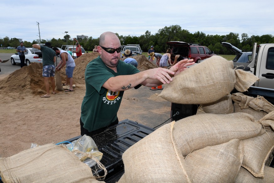 epa05871170 Locals fill up sandbags in preparation for Cyclone Debbie in Townsville, Queensland, Australia, 26 March 2017. The category 4 cyclone is expected to hit Queensland&#039;s far north coast l ...