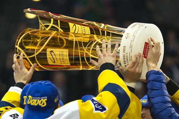 HC Davos Stuermer Perttu Lindgren, Mitte, stemmt den Meisterpokal in die Hoehe und feiert mit seinen Mitspielern den Titelgewinn nach ihrem Sieg im fuenften Playoff Finalspiel der National League A zw ...