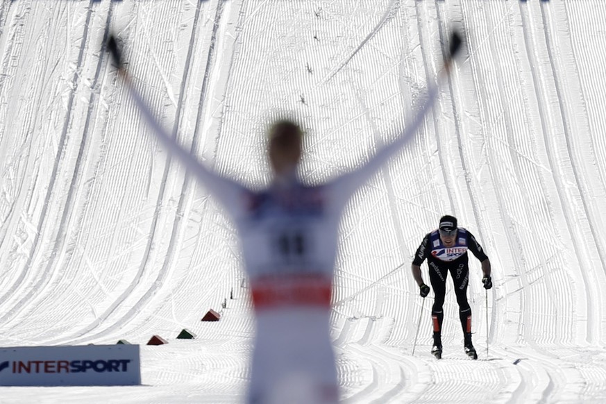 Dario Cologna of Switzerland skis behind Johan Olsson of Sweden on the last meters of the men&#039;s 50 km classic mass start race at the FIS Nordic Skiing World Championships in Lago di Tesoro, Val d ...