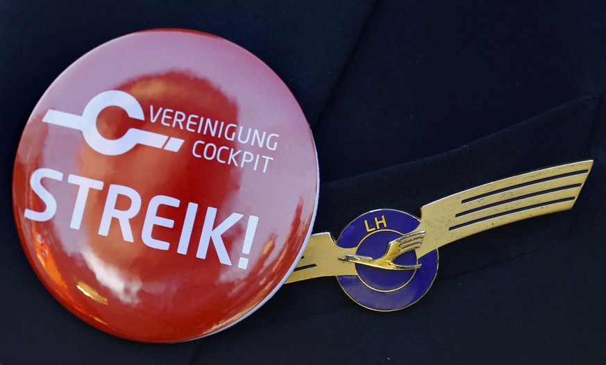 A pilot of German airline Lufthansa, sports a buttons reading &quot;strike&quot; on his uniform as he takes part in a demonstration at Fraport airport in Frankfurt, Germany April 2, 2014. REUTERS/Kai  ...