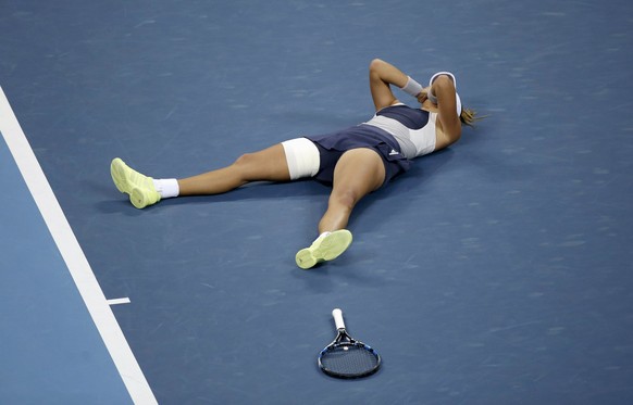 Muguruza sinkt nach ihrem Triumph auf den Pekinger Boden.