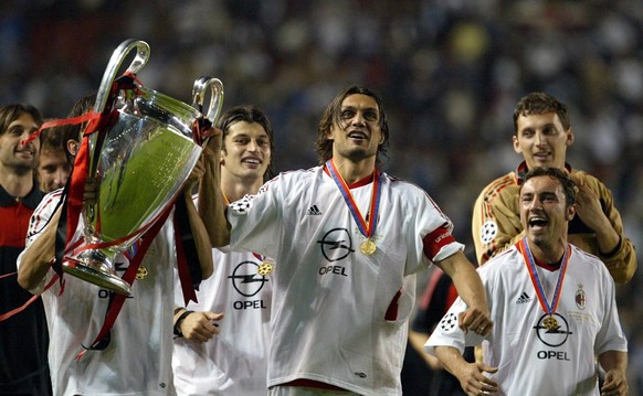 AC Milan captain Paolo Maldini (C) holds the Champions League trophy while celebrating with his teammates after defeating Juventus Turin during their Champions League soccer final in Manchester, Wedne ...