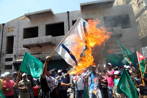 Palästinenser zünden israelische Flagge an.