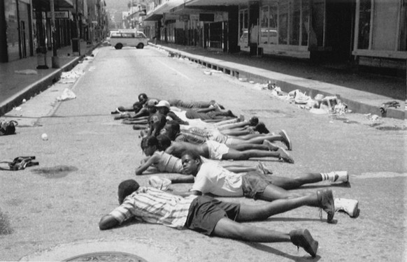Police forced suspected looters to lie in the road during a curfew period following explosions in the state owned Television house, in Port Of Spain, Trinidad, on July 30, 1990. A Moslem group is repo ...
