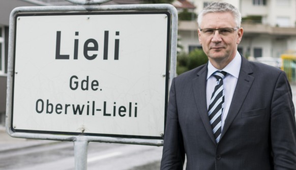 Andreas Glarner, Gemeindeammann Oberwil-Lieli, posiert eingangs Dorf Lieli vor der Ortstafel in Oberwil-Lieli, Kanton Aargau, am Mittwoch, 23. September 2015. Im Hintergrund links das Gebaeude seines  ...