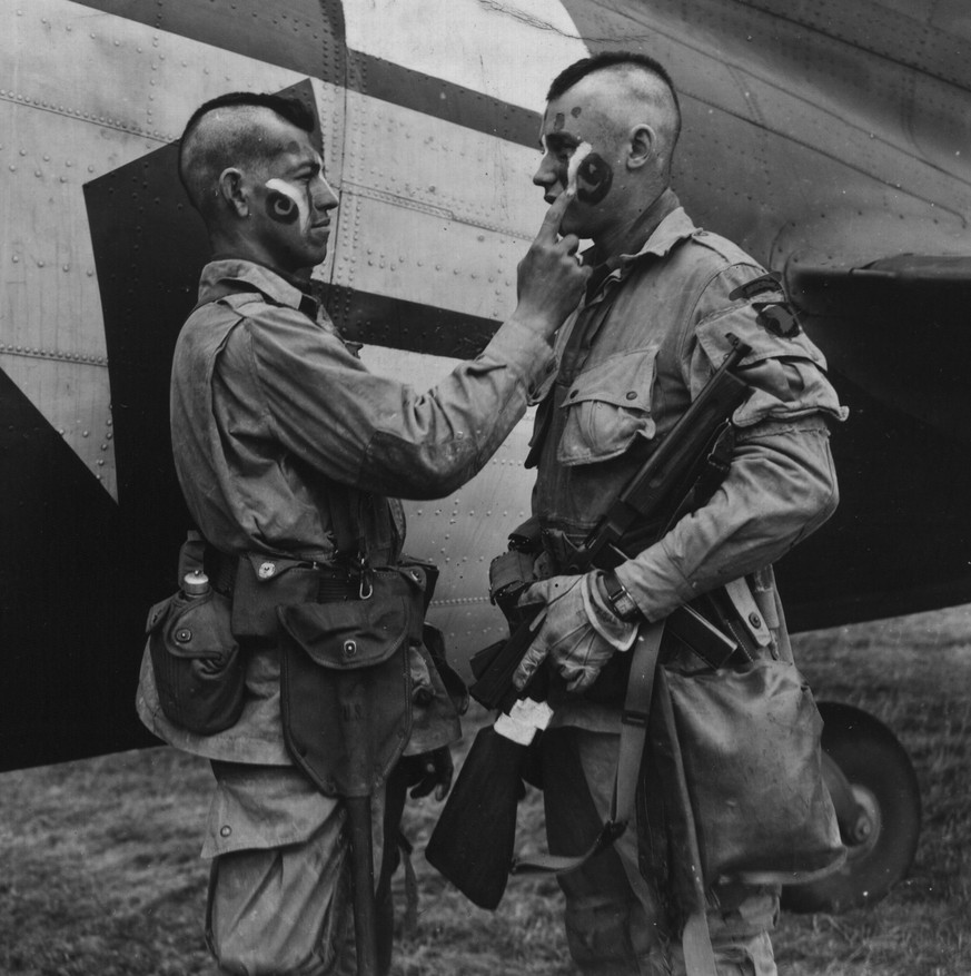 Männer der 101. Luftlandedivision der US Army beim Auftragen von Mohawk-Kriegsbemalung, kurz vor der Normandie-Invasion.