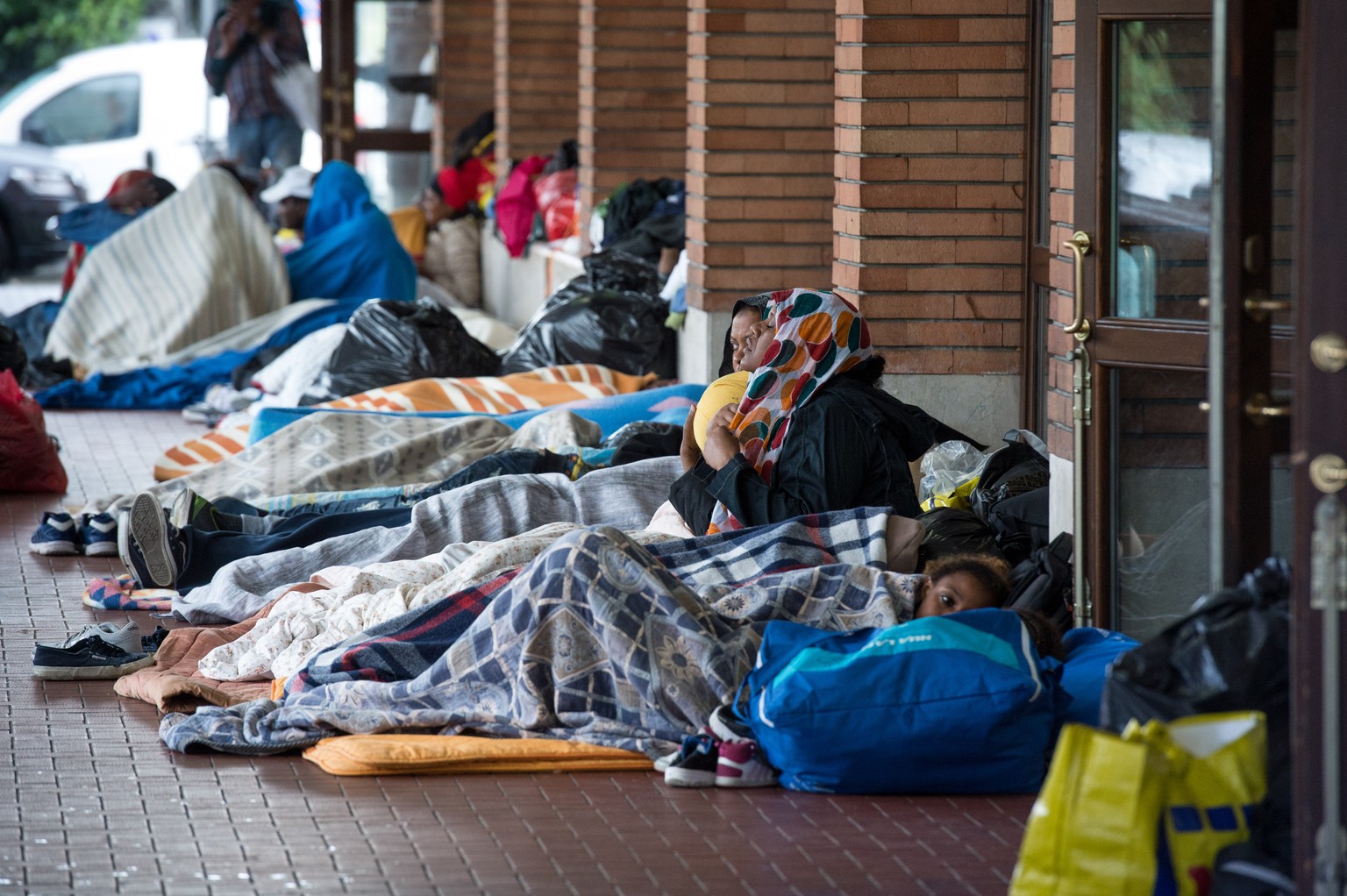 Fluechtlinge erhalten eine Mahlzeit von Freiwilligen der Tessiner Hilfsgruppe Associazione Firdaus, am Freitag, 5. August 2016, am Bahnhof in Como, Italien. Derzeit befinden sich in Como viele Fluecht ...