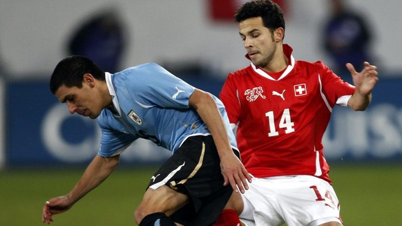 Swiss player Davide Chiumiento, right, fights for the ball with Uruguay&#039;s Andres Scotti, left, during a friendly test soccer match in the face of the 2010 soccer World Cup in South Africa between ...