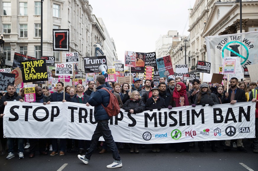 epa05770876 Participants of an anti-Trump protest hold placards as they march from the US embassy to 10 Downing Street in London, Britain, 04 February 2017. The protesters gathered in opposition to th ...