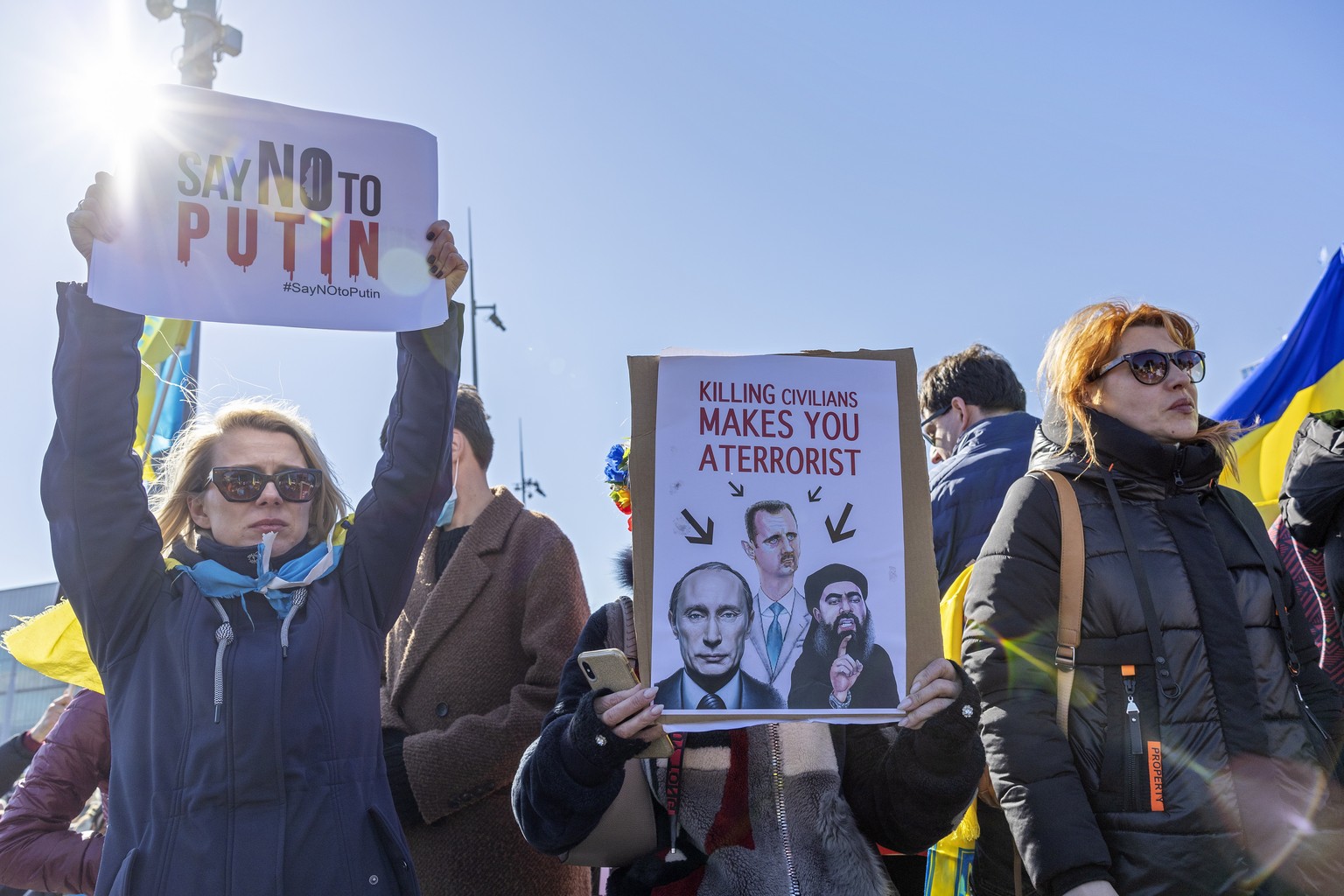 epa09786675 Demonstrators hold placards while protesting Russia&#039;s massive military operation against Ukraine during a rally on the place of the United Nations in Geneva, Switzerland, 26 February  ...