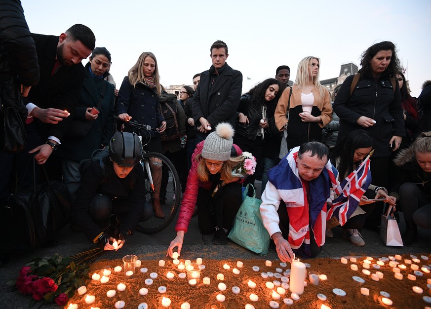 epa05866588 Londoners light candles as they gather for a vigil in Trafalgar Square in London, Britain, 23 March 2017. Thousands of Londoners gather in Trafalgar Square to remember the people killed in ...