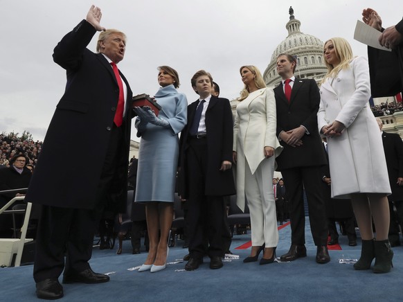 epa05735721 US President Donald J. Trump takes the oath of office as his wife Melania holds the bible and his children Barron, Ivanka, Eric and Tiffany watch as U.S. Supreme Court Chief Justice John R ...