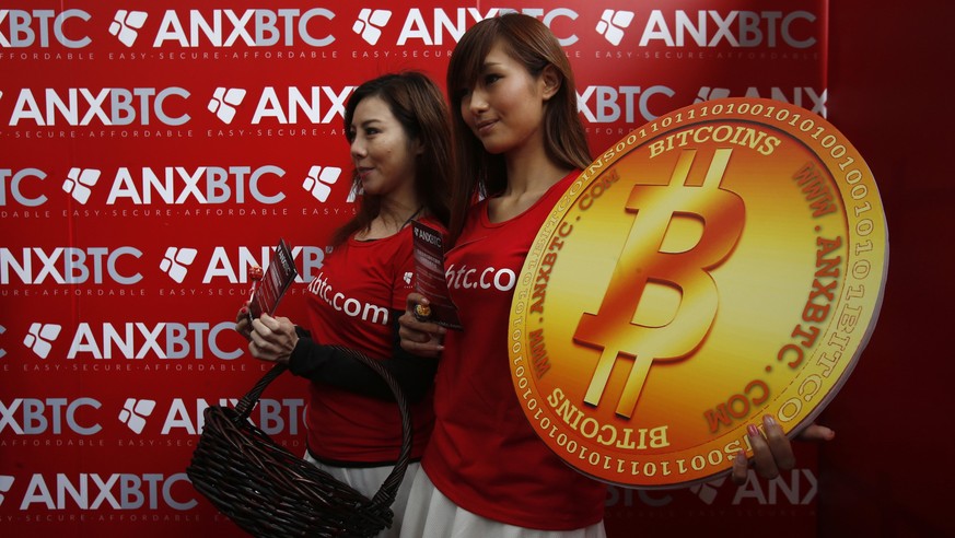 Attendants pose with a bitcoin sign during the opening of Hong Kong&#039;s first bitcoin retail store February 28, 2014. REUTERS/Bobby Yip (CHINA - Tags: BUSINESS)