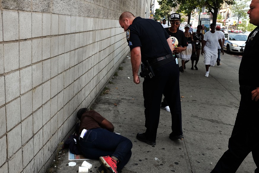NEW YORK, NY - SEPTEMBER 02: Police stand over a man passed out due to the drug K2 in an area which has witnessed an explosion in the use of K2 or &#039;Spice&#039;, a synthetic marijuana drug, in Eas ...