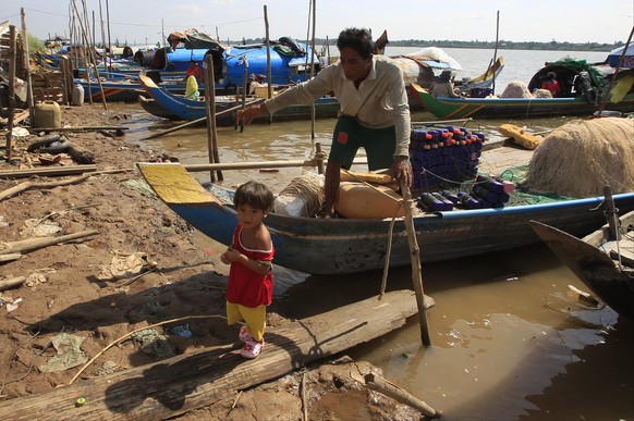 A man and grandchild prepares fishing nets at the Kbal Chroy village on the Mekong River bank near Phnom Penh, Cambodia, Thursday, May 17, 2018. A Chinese-backed plan for Cambodia to build the Mekong  ...