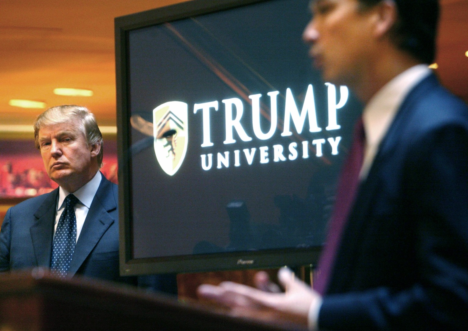 FILE- In this May 23, 2005 file photo, then real estate mogul and Reality TV star Donald Trump, left, listens as Michael Sexton introduces him at a news conference in New York where he announced the e ...