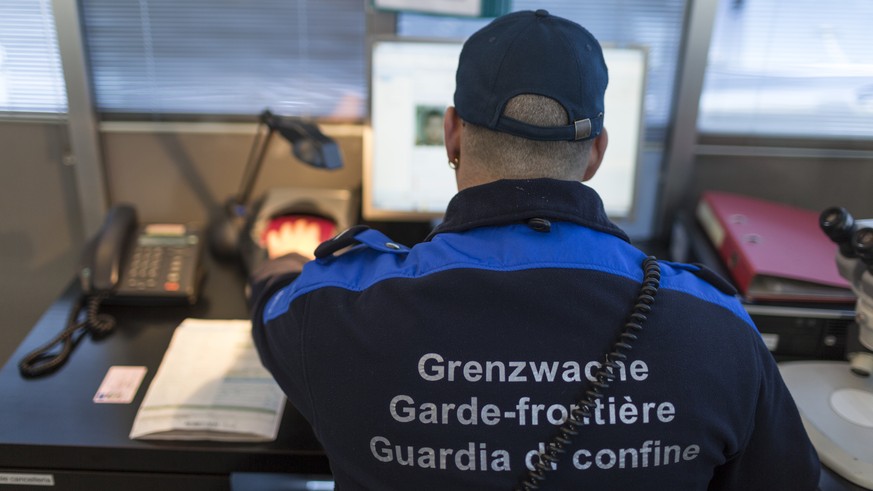 THEMENBILD ZU MASSNAHMEN TERRORBEKAEMPFUNG --- A member of the Swiss Border Guard Corps scanns a passport, captured at the border post in Chiasso, Switzerland, on October 23, 2014. (KEYSTONE/Gaetan Ba ...