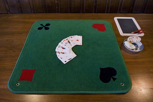 Cards, table carpet, sponge, slate and pen used in the traditional Swiss card game &quot;Jassen&quot; lie on a table at the restaurant Ochsen in Luetzelflueh in the canton of Berne, Switzerland, pictu ...
