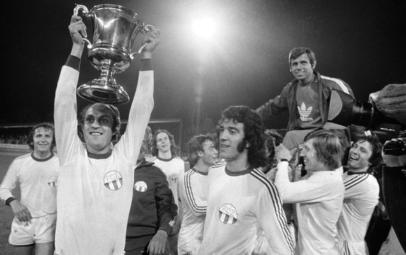 Die Spieler des FC Zuerich werden am 11. Mai 1974 in Zuerich als Schweizermeister gefeiert. V.l.n.r, jubeln die FCZ-Spieler Ernst Rutschmann, Renzo Bionda mit Pokal, Rene Botteron im Hintergrund und T ...