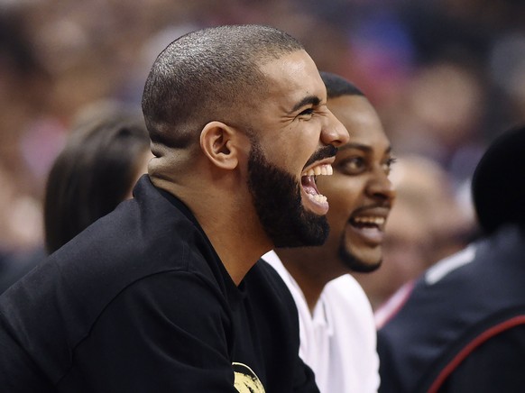 Rapper Drake laughs during the first half of an NBA basketball game between the Golden State Warriors and the Toronto Raptors on Wednesday, Nov. 16, 2016, in Toronto. (Frank Gunn/The Canadian Press vi ...