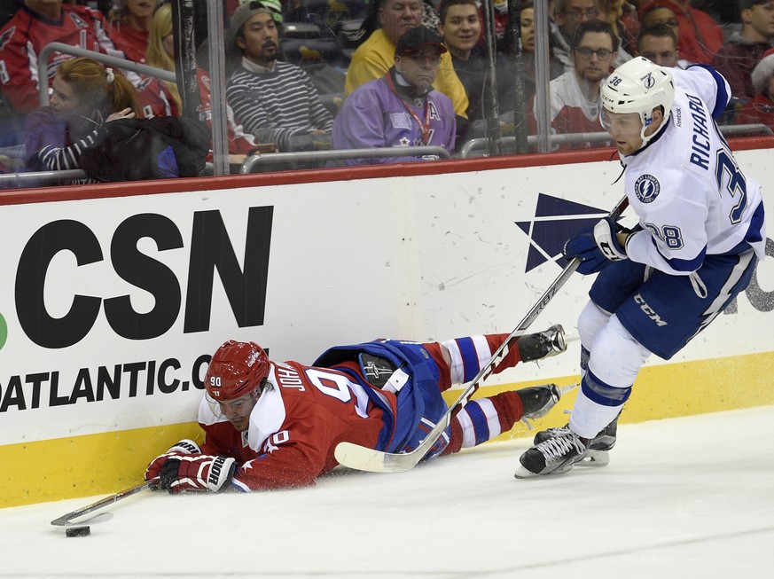 Washington Capitals left wing Marcus Johansson (90), of Sweden, reaches of the puck as he lies on the ice against Tampa Bay Lightning center Tanner Richard (38) during the second period of an NHL hock ...