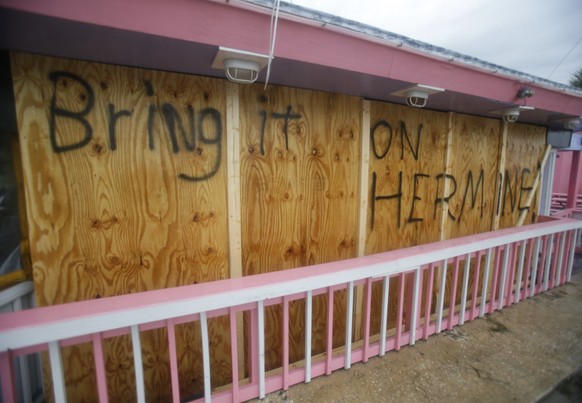 A hand painted sign on a boarded up bar is seen as Hurricane Hermine nears the Florida coast, Thursday, Sept. 1, 2016, in Cedar Key, Fla. ﻿Hurricane Hermine gained new strength Thursday evening and ro ...