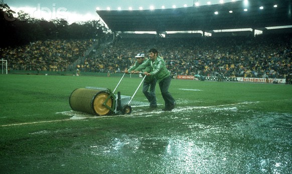 03 Jul 1974, Frankfurt, Germany --- Mit Wasserwalzen versuchen Helfer den uberschwemmten Platz bespielbar zu machen, aufgenommen wurde das Foto beim Spiel Polen gegen Deutschland während der Fußball-W ...