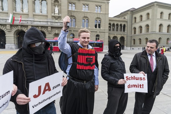 Rechts der SVP-Nationalrat Walter Wobmann, SO, der am 15. März in Bern zur Lancierung der Unterschriftensammlung zur Initiative für ein Verhüllungsverbot&nbsp;mit Statisten posiert.