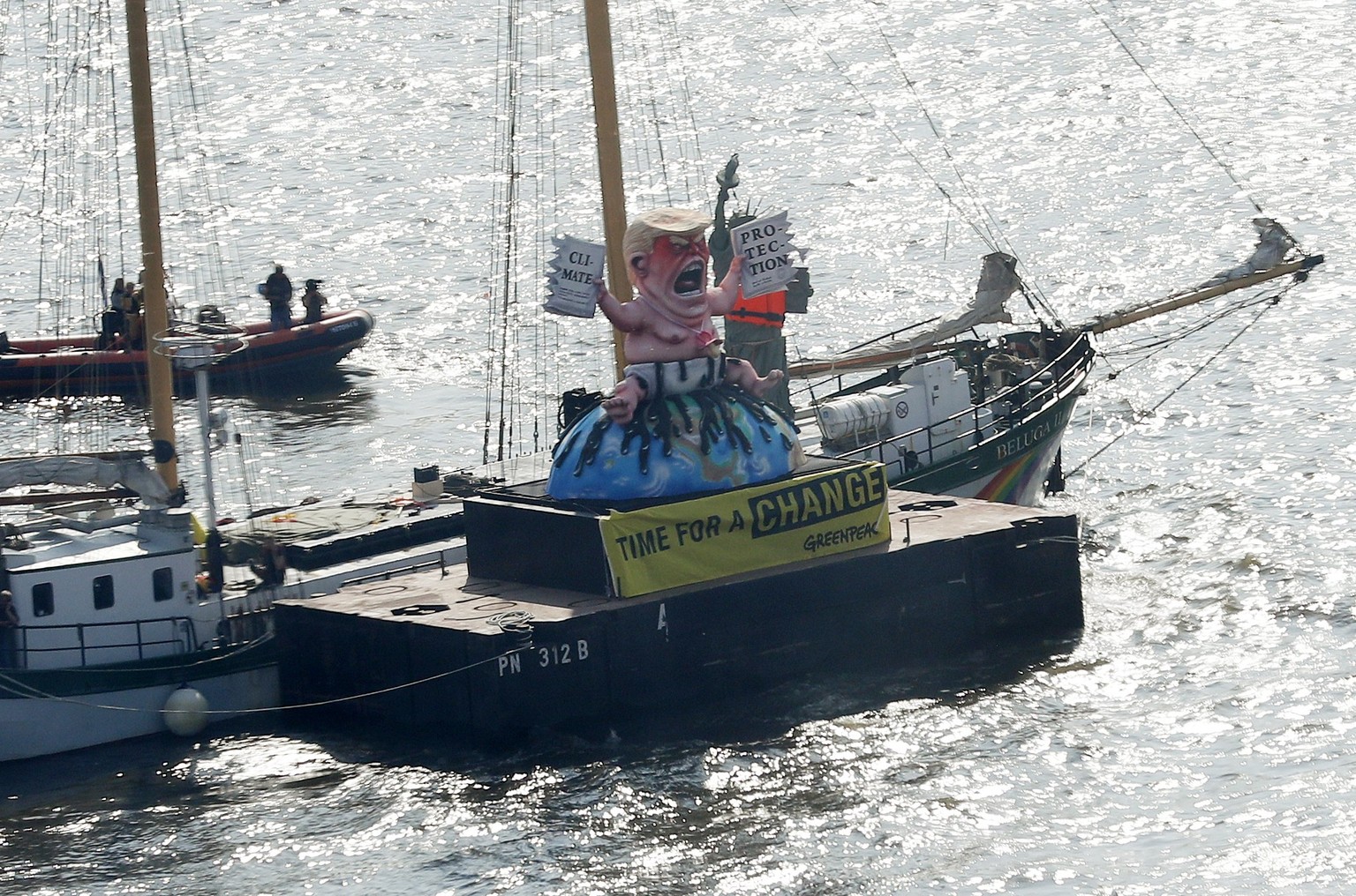 epa06073564 Greenpeace float with a mock depicting US President Donald J. Trump as a baby sitting on the earth and signs &#039;Climate Protection&#039; and &#039;Time for a Change&#039; during a prote ...