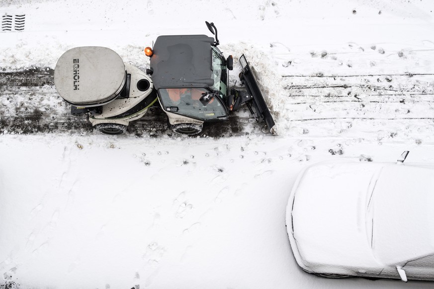 Ein Fahrzeug befreit den Gehweg vom Schnee und streut Salz auf, aufgenommen am Sonntag, 8. Januar 2017 in Zuerich. (KEYSTONE/Ennio Leanza)