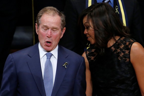 Former president George W. Bush (L) and First Lady Michelle Obama talk during a memorial service following the multiple police shootings in Dallas, Texas, U.S., July 12, 2016. REUTERS/Carlo Allegri