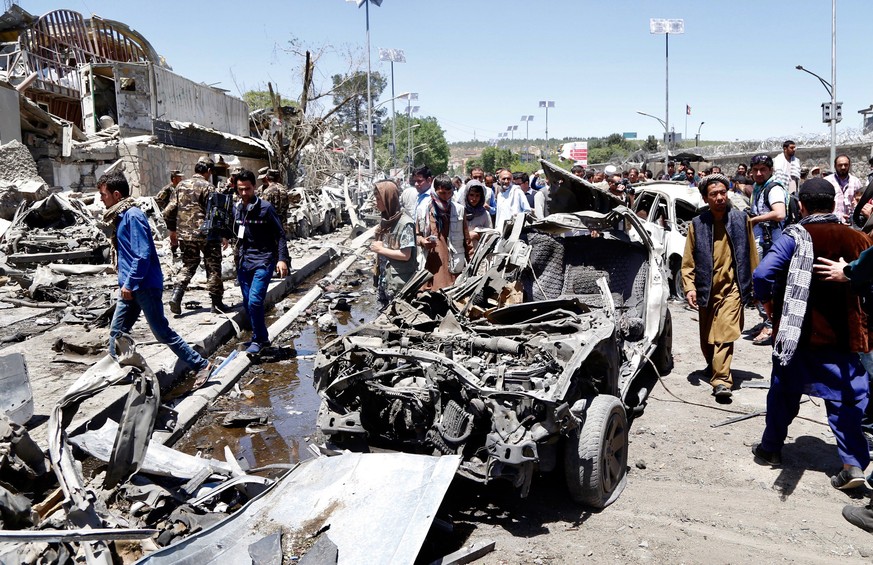 epa06000673 People survey the the scene of a suicide bomb attack in Kabul, Afghanistan, 31 May 2017. At least 80 people were killed and over 350 were wounded in a suicide bomb attack near Kabul&#039;s ...